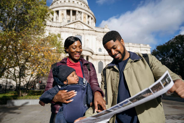 Smiling young family looking at London travel brochure stock photo