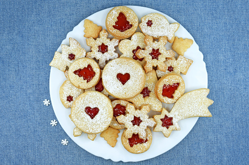 Christmas or New Year homemade sweet present in wooden box. Traditional Austrian christmas cookies - Linzer biscuits filled with red raspberry jam. Festive decoration. Copy space