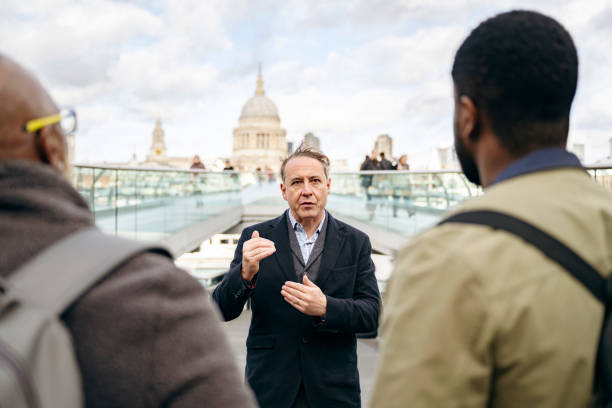 ロンドンミレニアム歩道橋で観光客と話すガイド - english culture talking men listening ストックフォトと画像