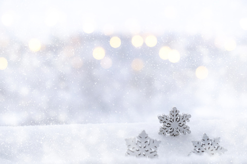 Copos de nieve sobre un fondo borroso de luces abstractas brillantes, plateadas y doradas, desenfocadas. Año Nuevo, antecedentes de vacaciones de Navidad photo