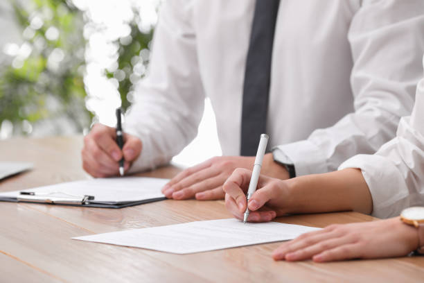 istock Woman signing contract at table in office, closeup. 1443823935