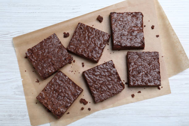 istock Delicious chocolate brownies on white wooden table, top view 1443824459