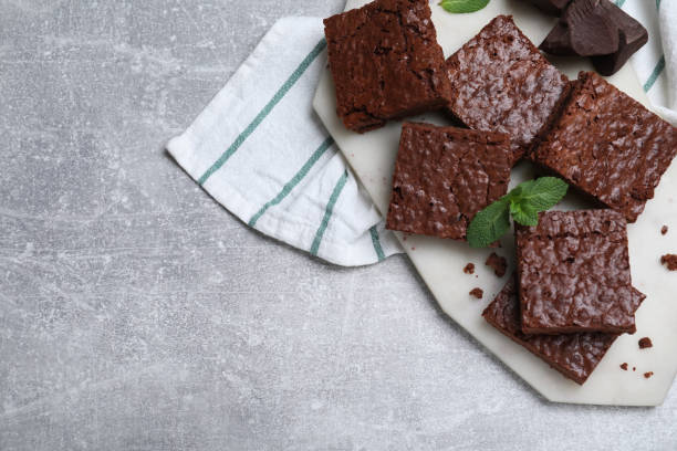 istock Delicious chocolate brownies with fresh mint on grey table, top view. Space for text 1443824488