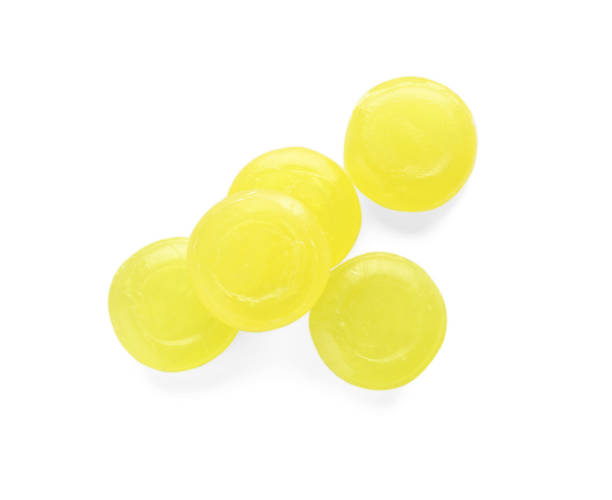 istock Many yellow cough drops on white background, top view 1443825165