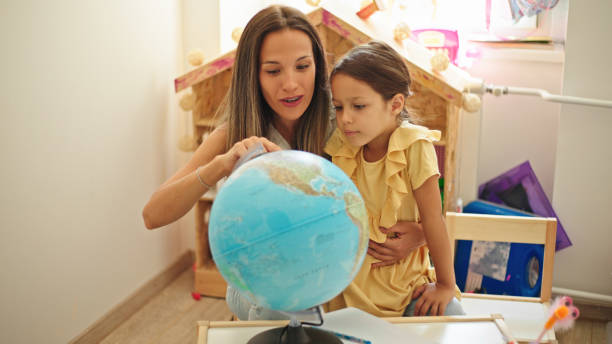 istock Mother and daughter learning geography on a world globe 1443825734