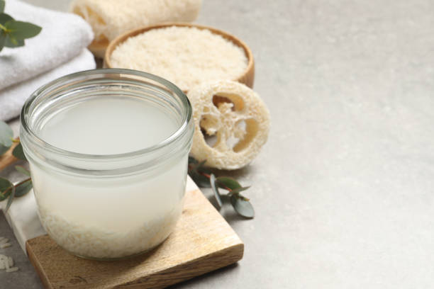istock Glass jar with rice soaked in water on light grey table. Space for text 1443825799
