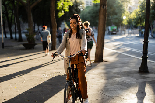 African american woman with braided hair on bicycle riding in the city