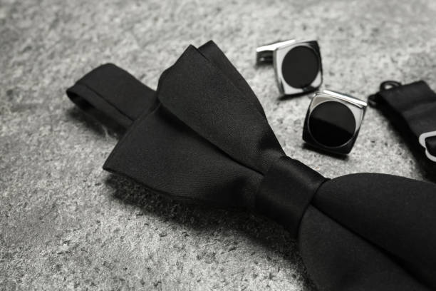 istock Stylish black bow tie and cufflinks on grey stone background, closeup 1443828875