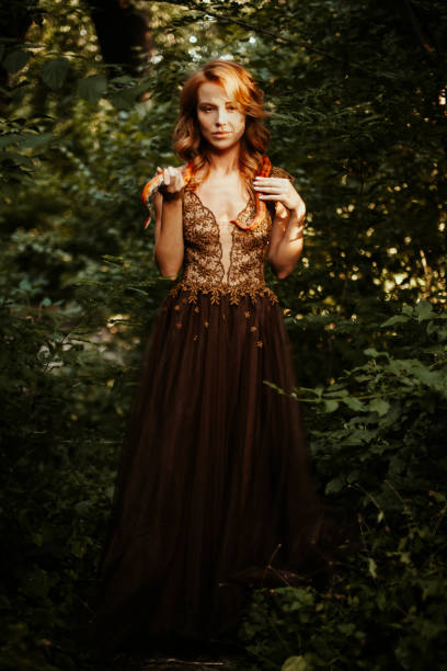 istock Beautiful redhead woman with orange snake 1443831257