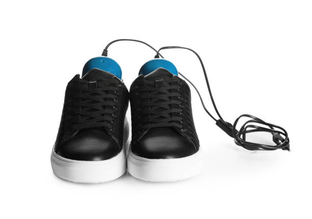 白い背景にスタイリッシュな靴と現代の電気履物乾燥機のペア - air freshener ストックフォトと画像