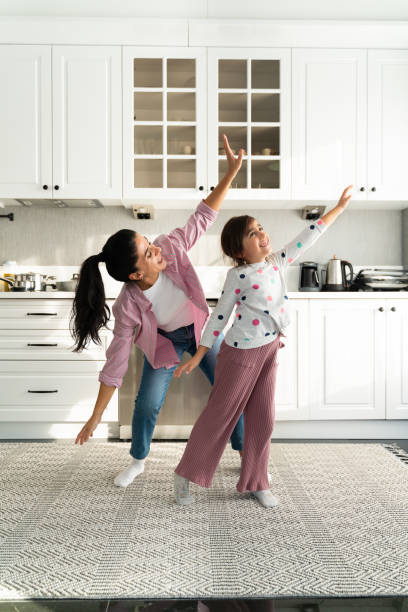istock Happy young mom and little daughter dance at home 1443833607