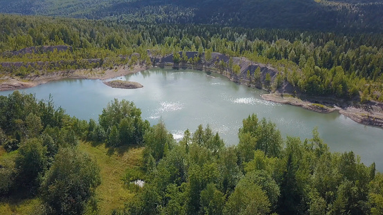 The view from the drone. Clip. Beautiful summer view of the blue lake, houses, mountains and blue sky