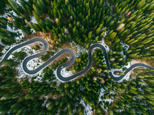 вид с воздуха на извилистую дорогу через доломитовые альпы осенью - curve driving winding road landscape стоковые фото и изображения