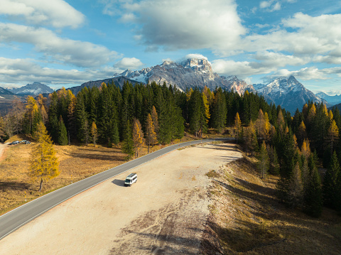 Aerial view of  white camper van parked in  forest in national park in Dolomites in  autumn
