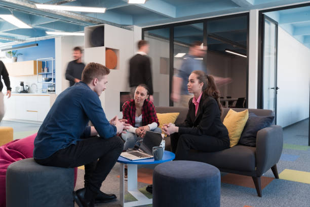 istock Multiethnic startup business team on meeting in a modern bright open space coworking office. Brainstorming, working on laptop. Group of coworkers walking around in motion blur. 1443839921