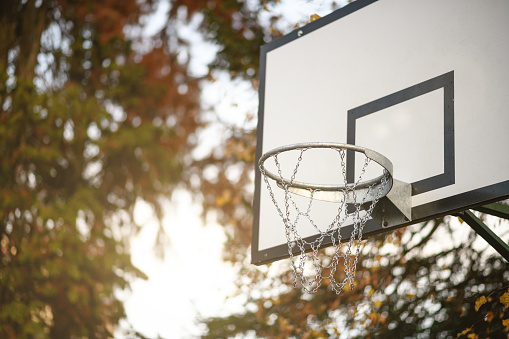 Basketball goal with a tennis court in the background.