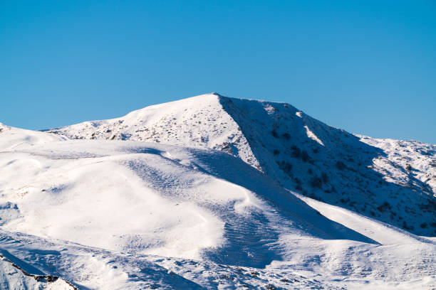 istock Snow covered hmountain peak and blue sky 1443844445