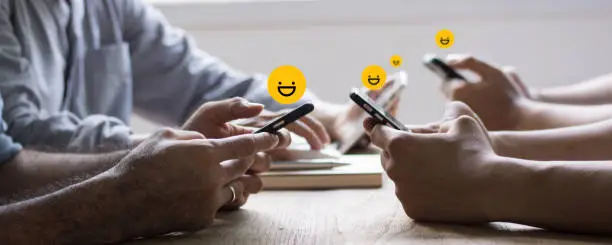 Photo of review rating and feedback, the best and excellent admire by reviewer, close up on customer hand pressing on smartphone screen with gold emoji faces