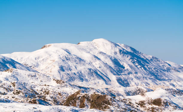 istock Snow covered hmountain peak and blue sky 1443845781