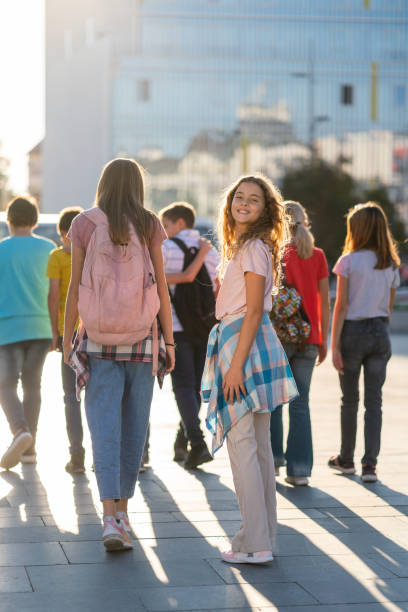 School children with backpacks walking in the city stock photo