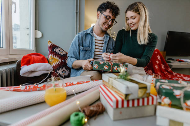 istock Cheerful young couple wrapping Christmas presents 1443847384