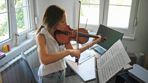 istock Young female violinist practicing at home 1443850394