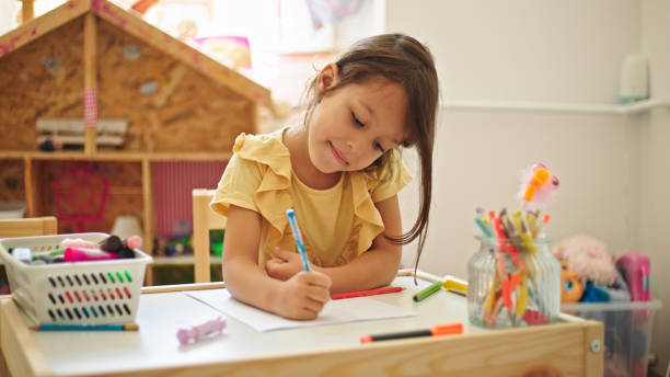 istock Little girl drawing while sitting at the table in her room 1443850875