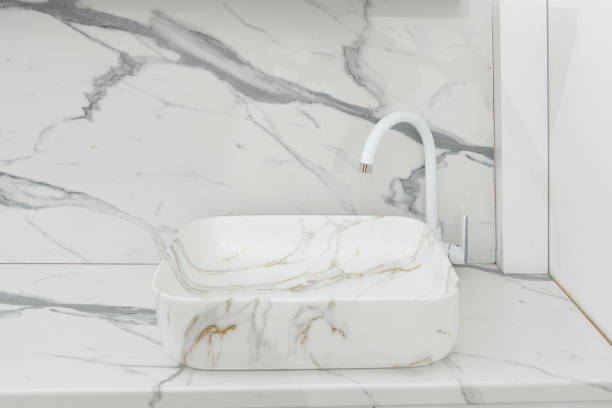 istock Stylish white marble sink on a light countertop in a modern bathroom 1443853324