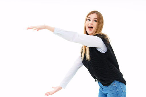 a blonde in a black knitted vest shows hands on a white background. space for object, images, inscription or advertising. work for students,training professional courses. discounts and sales in stores