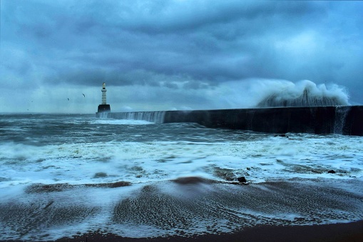A stormy sea and sky with a small breaking wave taken from south breakwater pier beach in Torry, Aberdeen, Scotland.