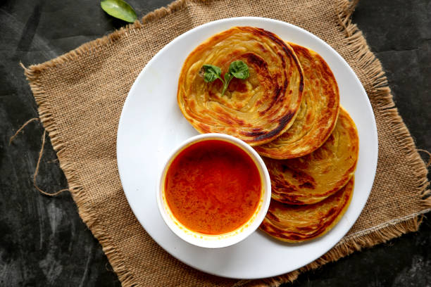 paratha bread or canai bread or roti maryam, favorite breakfast dish. served on plate paratha bread or canai bread or roti maryam, favorite breakfast dish. served on plate roti canai stock pictures, royalty-free photos & images