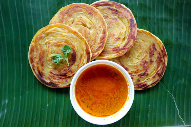 paratha bread or canai bread or roti maryam, favorite breakfast dish. served on banana leave paratha bread or canai bread or roti maryam, favorite breakfast dish. served on banana leave roti canai stock pictures, royalty-free photos & images
