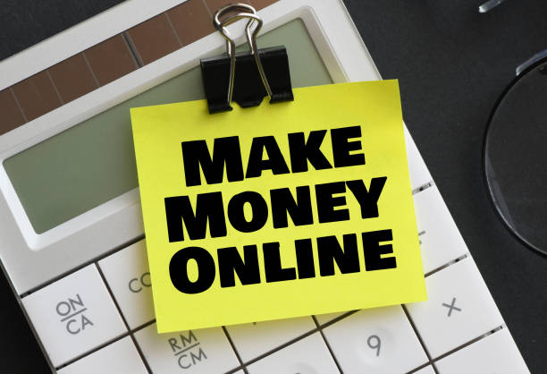 istock MAKE MONEY ONLINE words on a small piece of paper placed on a calculator. 1443861507