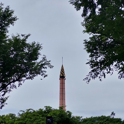 tower in the middle of the park with a fountain