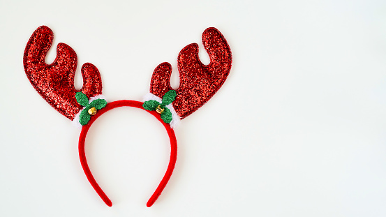 Closeup of red shiny christmas horns on white background,decorative headband,top view,flat lay,copy space.Decor concept for christmas or new year party.Christmas antlers