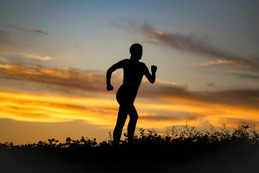 Silhouette of a woman running. Unrecognizable young female.
