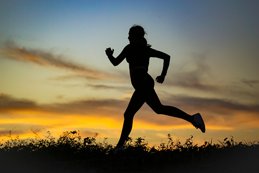 Silhouette of a woman running. Unrecognizable young female.