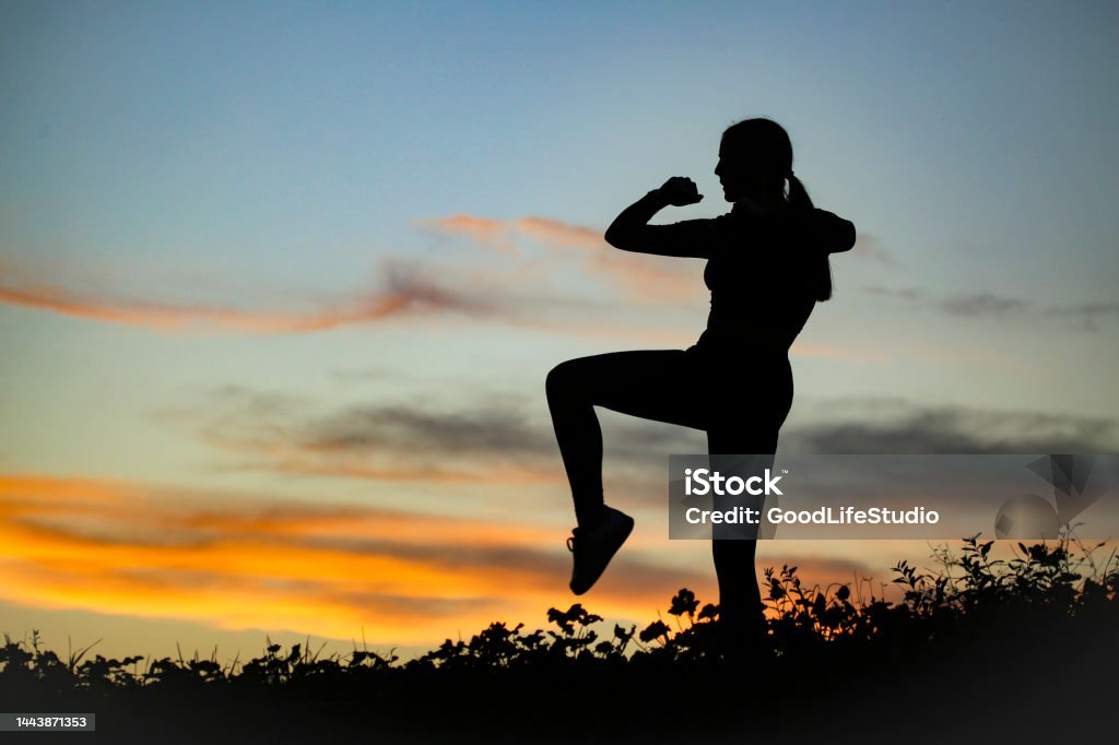 Kickboxing Silhouette of a female fighter in knee kick position. Unrecognizable young woman. 20-24 Years Stock Photo