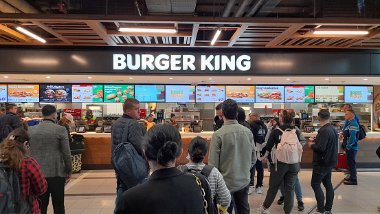 People Standing, Ordering Food, Waiting For Ordered Food At Burger King Restaurant In Schiphol International Airport Amsterdam North Holland Europe