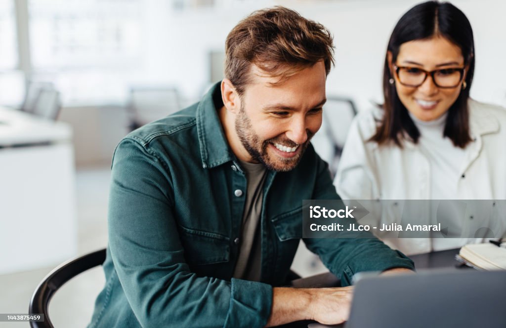 Odnoszący sukcesy biznesmen korzystający z laptopa na spotkaniu z kolegą - Zbiór zdjęć royalty-free (Ludzie) Odnoszący sukcesy biznesmen korzystający z laptopa na spotkaniu z kolegą - Zbiór zdjęć royalty-free (Ludzie)