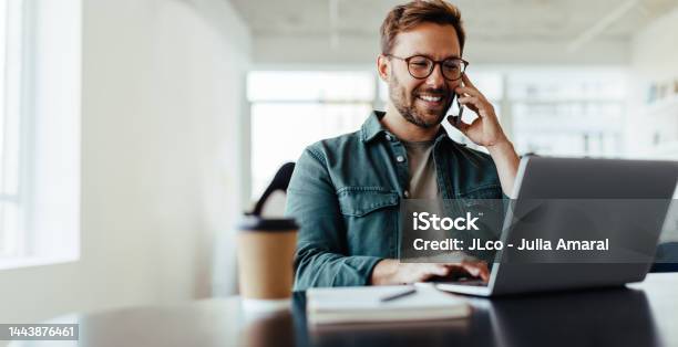 Software Designer Speaking To His Client On The Phone In An Office Stock Photo - Download Image Now