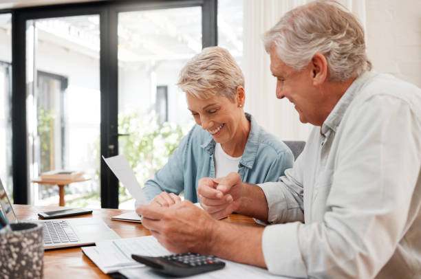 couple âgé, finance et investissement ou payer leurs factures à la maison. l’homme et la femme mariés utilisent la calculatrice, vérifiant leur budget et leur plan de retraite. personnes d’âge mûr souriantes qui planifient leur future pension - senior couple senior adult pension couple photos et images de collection