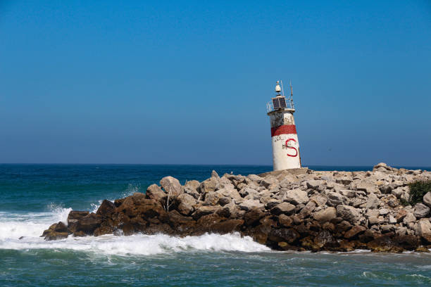 a lighthouse on the rocks by the sea