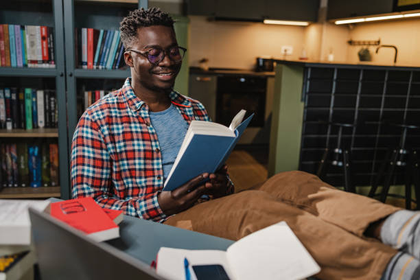 istock African-American man reading a book at home 1443886896