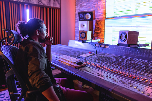 view of sound producing equipment at recording studio with armchair on foreground