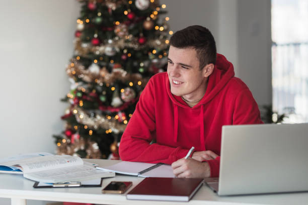 glücklicher männlicher student, der sich notizen macht und in den winterferien lernt - male education college student nerd stock-fotos und bilder