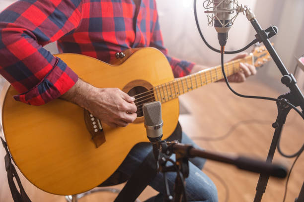 zbliżenie na starszego dorosłego kaukaskiego muzyka grającego na gitarze akustycznej w studiu nagraniowym - acoustic guitar guitarist country and western music guitar zdjęcia i obrazy z banku zdjęć