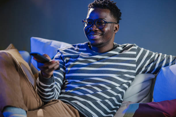 istock Young man at home watching TV 1443887776