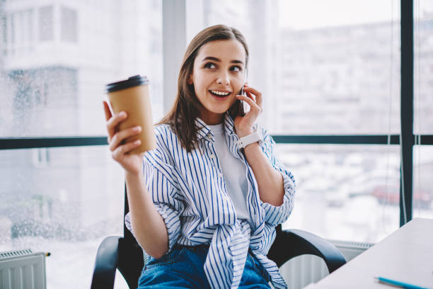 istock Happy female employee using smartphone connection for making positive app conversation with friendly contact, pretty woman enjoying cellphone communication during coffee break in office interior 1443889941