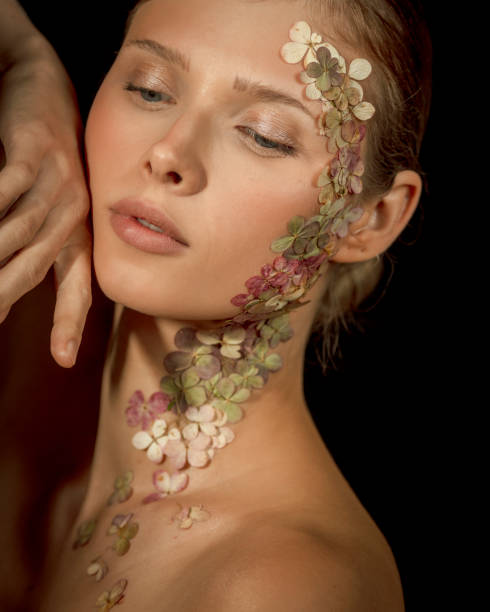 Woman face covered with flower petals